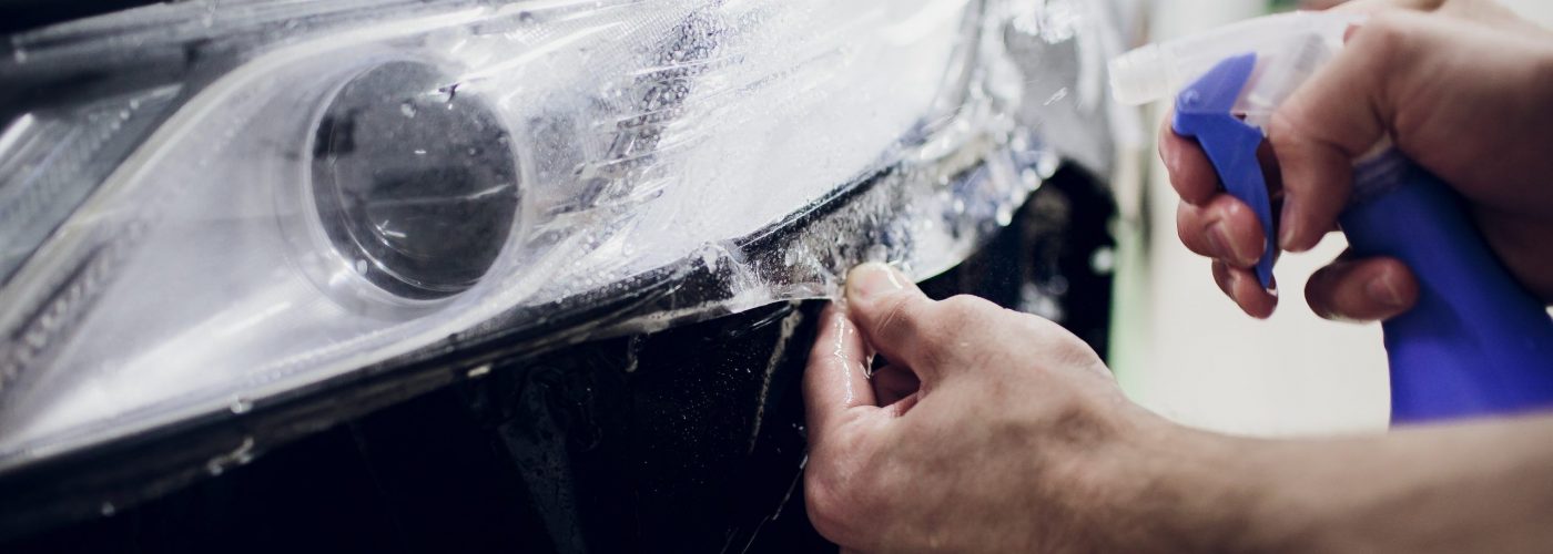Worker hands installs car paint protection film